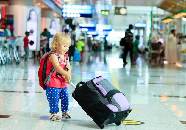 Девочка с чемоданом в аэропорту