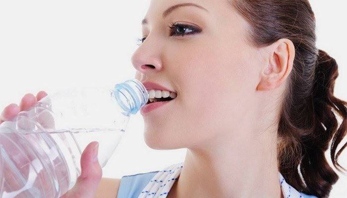Девушка пьет воду для похудения