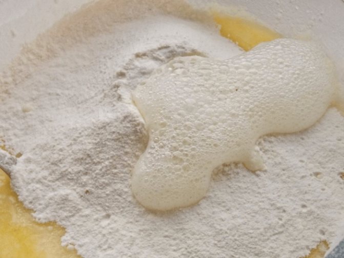 Добавить сахарный песок, сливочное растопленное масло, просеянную муку и гашеную соду