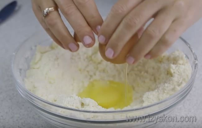 Добавляем яйца в массу и начинаем замешивать тесто для вкусного пирога с творогом.
