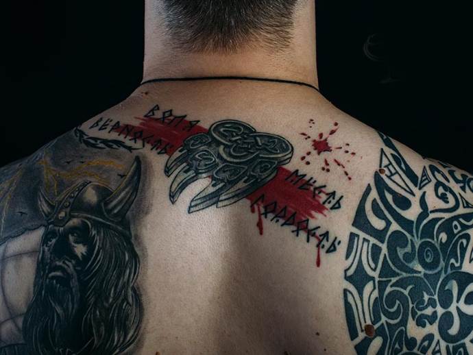 мужчина со славянскими татуировками на спине