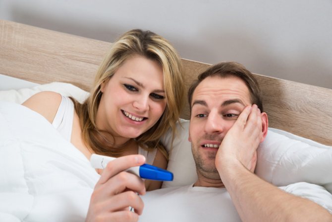 Радостные супруги рассматривают тест на беременность