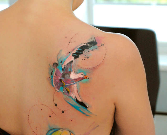 Татуировка на плече девушки - чайка