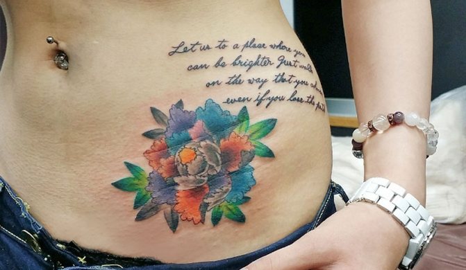 Татуировка с разноцветным пионом и надписью